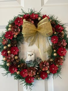 a christmas wreath with an owl and pine cones