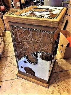 a cowhide covered box sitting on top of a tile floor