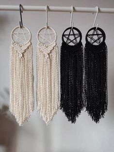 three black and white dream catchers hanging from a rack