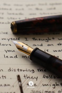 a fountain pen sitting on top of an open book with writing in english and french