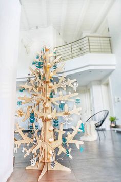 a tree made out of wooden pieces in the middle of a room with white walls