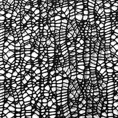 black and white photograph of an intricate lace pattern on fabric, with small holes in the middle