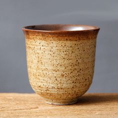 a brown cup sitting on top of a wooden table