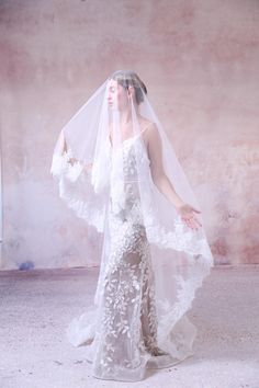 a woman in a wedding dress with a veil over her head