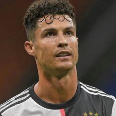 a close up of a soccer player wearing a black and white uniform with gold stars on his forehead