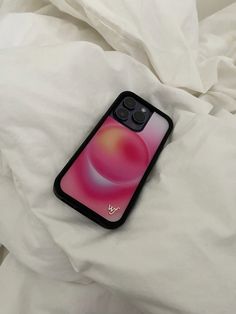 an iphone case sitting on top of a white bed covered in sheets and pillows,