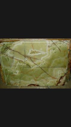 green marble with red veining on the edges and brown lines running down it's sides