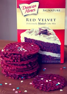 a box of red velvet cake mix next to a stack of cookies