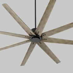 a ceiling fan with wooden blades hanging from it's center point on a gray background