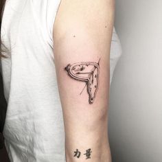 a woman with a tattoo on her arm has a clock in the shape of a letter