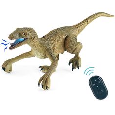 a toy t - rex walking next to a remote control