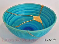 a blue and gold bowl sitting on top of a white table