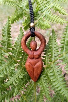 a wooden ornament hanging from a fern tree