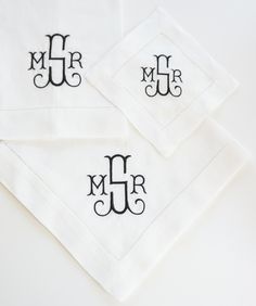 three monogrammed napkins with black ink on them