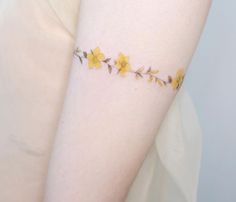 a woman's arm with yellow flowers on it