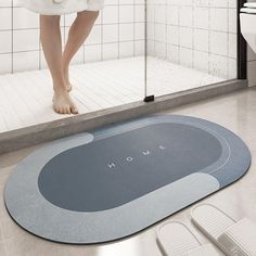 a woman standing in front of a shower door with her feet on the floor next to it