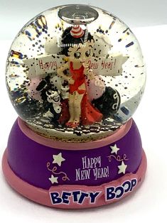 a snow globe with an image of a woman in a red dress and stars on it