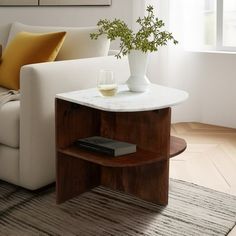 a living room with a couch, table and vase on the coffee table next to it