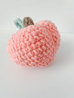 a crocheted apple sitting on top of a white table