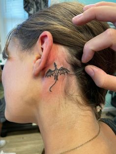 a woman with a small tattoo on her neck