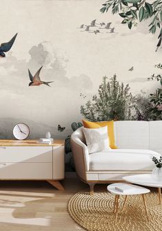 a living room with birds flying in the sky and plants on the wall behind it