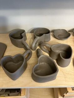 some heart shaped bowls and spoons are on a table in front of other items