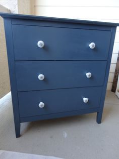 a blue dresser with white knobs on it