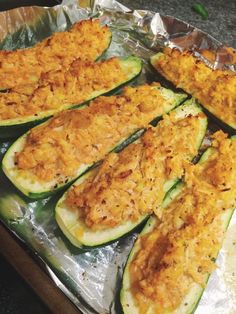 zucchini stuffed with cheese and other toppings on aluminum foil