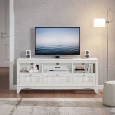 a flat screen tv sitting on top of a white entertainment center in a living room