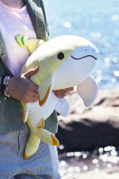 a person holding a stuffed animal near the water