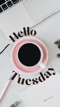 a cup of coffee sitting on top of a white table next to a laptop computer