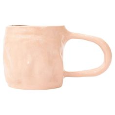 a pink coffee mug with a handle on a white background, it is made out of ceramic