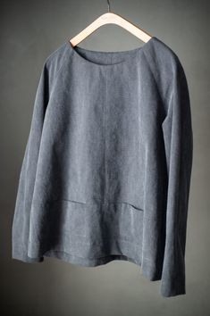 a gray sweater hanging on a hanger with clothes pins attached to the top of it