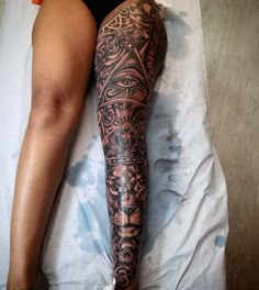 a woman laying on top of a bed next to a leg with tattoos on it