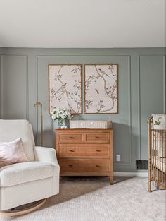 a baby's room with a rocking chair, crib and two paintings on the wall