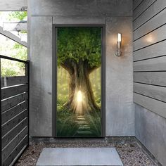 an open door leading to a tree with light coming in from behind it on the side of a building