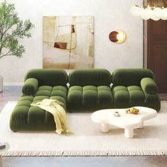 a living room filled with green couches and a white coffee table