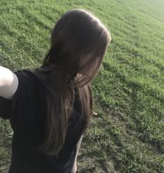 a woman standing on top of a lush green field