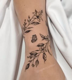 a woman's foot with flowers and leaves on it