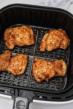 four pieces of chicken cooking in an air fryer