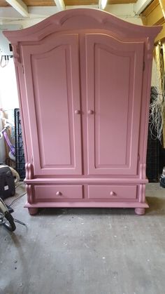 a large pink armoire sitting in a room