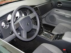 the interior of a car with grey leather seats and dashboard controls, including steering wheel