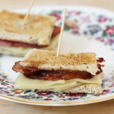 two sandwiches on a plate with toothpicks sticking out of the meat and cheese