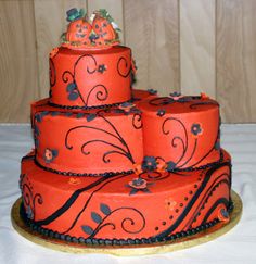 a three tiered cake decorated with orange and black decorations