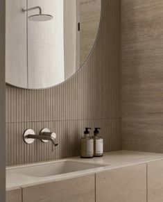 a bathroom with a sink, mirror and soap dispenser on the counter