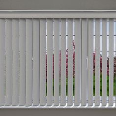 a white bench sitting in front of a window covered in slatted metal blinds