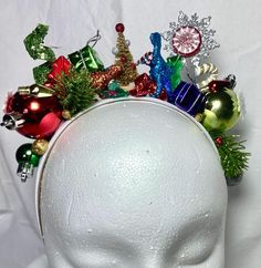 Add holiday spirit to your hairstyle with this fun, bright , tacky headband ! Handmade using festive holiday ornaments that sparkle and shine, set on a 1 inch wide, satin headband . Each unique headband is handcrafted with great care and  attention to detail . A perfect and fun  accessory for all of your holiday festivities!  Headband is 13 inches from end to end, over the head .   Headband contains small embellishments that can be a choking hazard to small children.  HANDLE EMBELLISHED HEADBAND