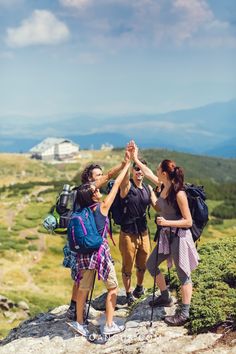 group of hikers giving high five on top of a mountain