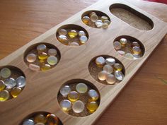 a wooden board with six holes filled with oil