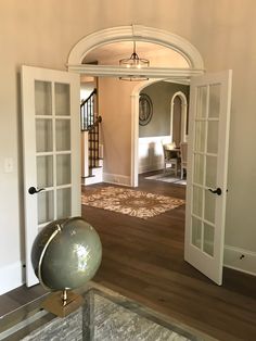 an open door leading to a living room with a large ball on top of it